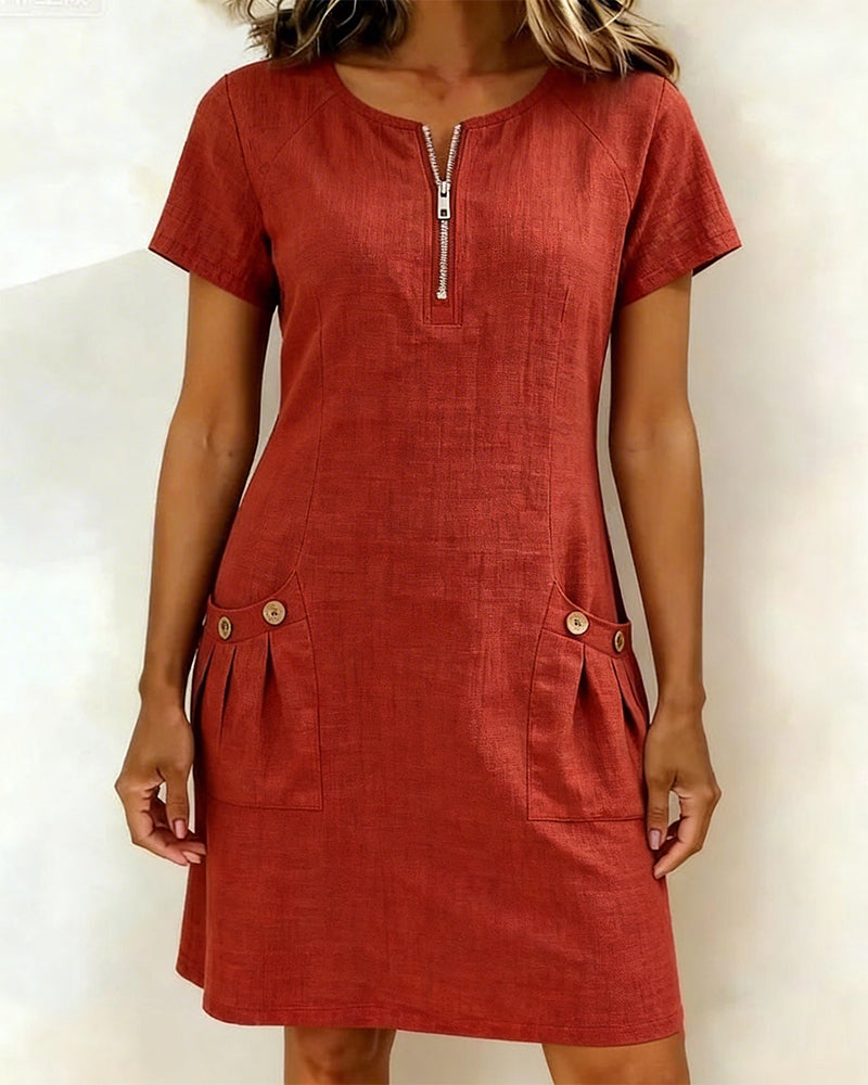 Red short-sleeve dress with zipper front and buttoned pockets in a studio setting.