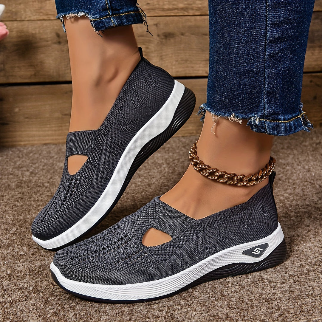 Gray non-slip orthopedic shoes with anklet, denim jeans on carpeted floor.