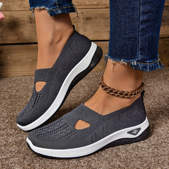Gray non-slip orthopedic shoes with anklet, denim jeans on carpeted floor.