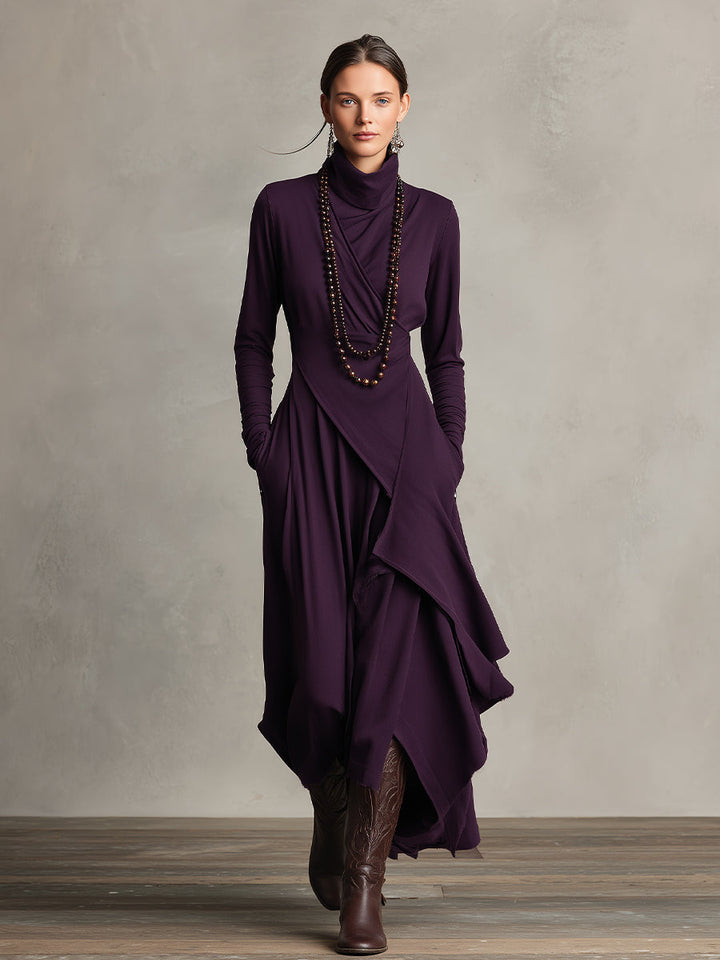 Woman in a purple stretch maxi dress with long sleeves and layered details, wearing long necklace, in a studio setting.