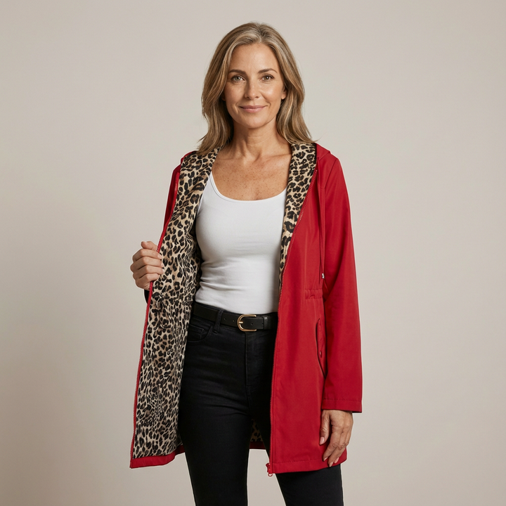 Woman wearing red reversible hooded coat with leopard print lining, standing in a studio.