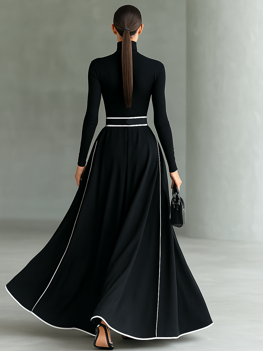 Back view of black long sleeve maxi dress with white trim and flowing skirt in a studio setting.