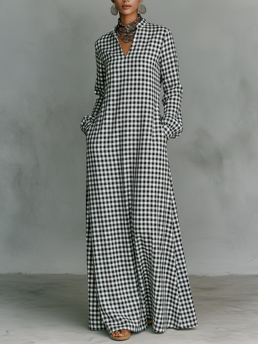 Black and white plaid V-neck long-sleeved maxi dress on model in a studio with a gray backdrop.