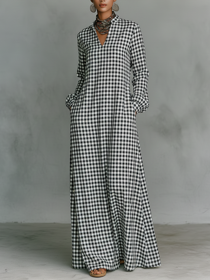 Black and white plaid V-neck long-sleeved maxi dress on model in a studio with a gray backdrop.