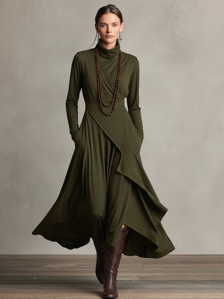 Woman in an olive green stretch maxi dress with flowing layers and long sleeves, in a studio setting.
