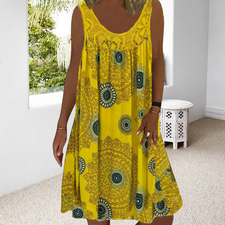 Woman in yellow printed dress in a bright room with view of greenery.