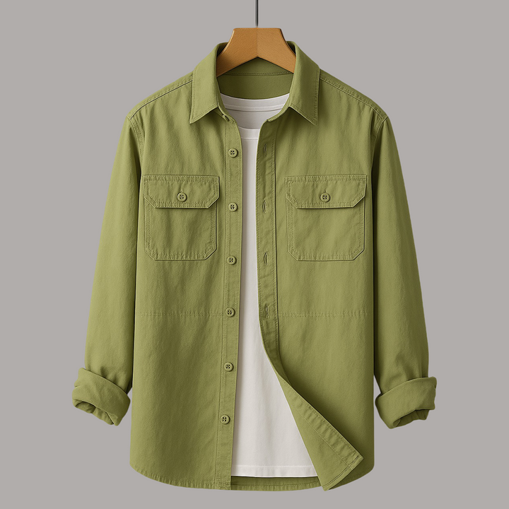 Olive shirt with chest pockets over a white tee on wooden hanger, gray studio background.