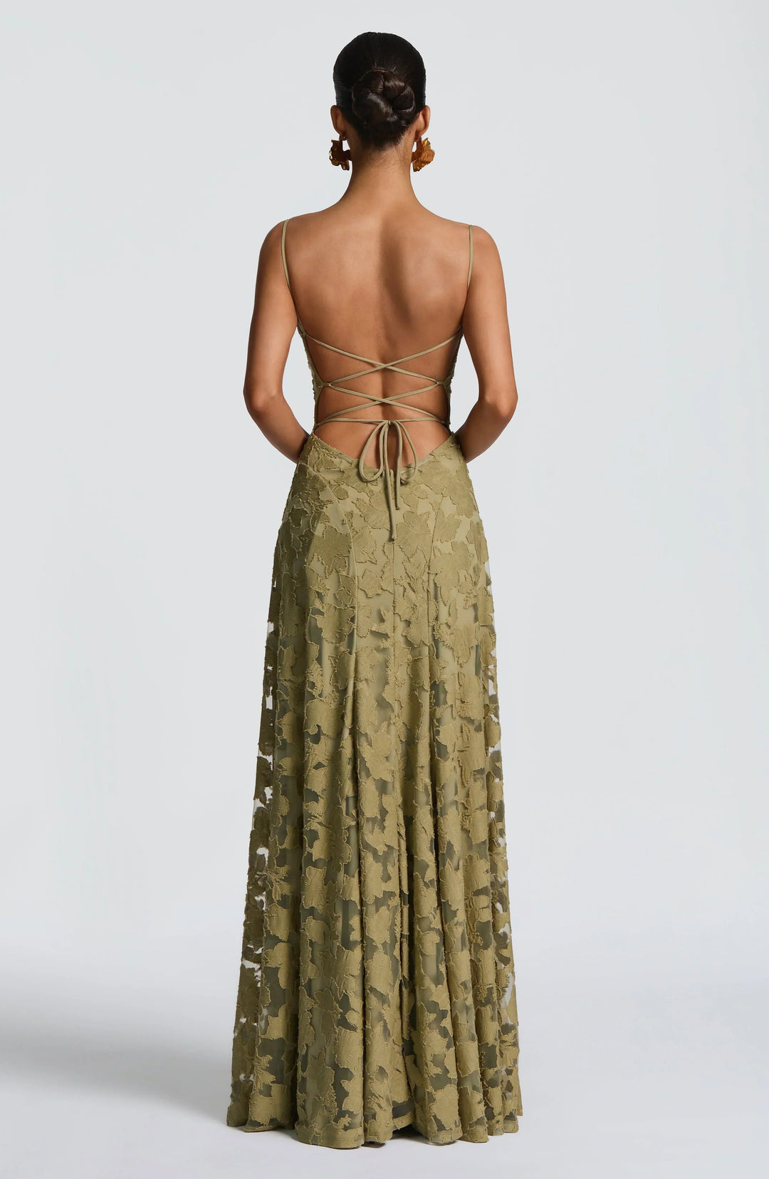 Back view of olive green maxi dress with criss-cross strap detailing in a studio setting.
