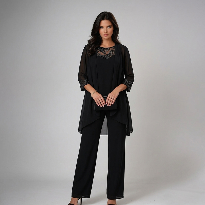 Model in sophisticated black three-piece set with lace, holding a clutch in a studio setting.