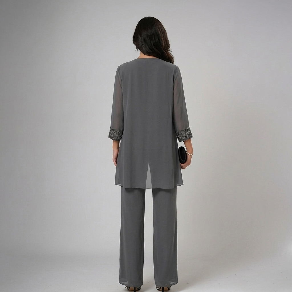Back view of model in gray set with lace accents, holding clutch in a studio setting.
