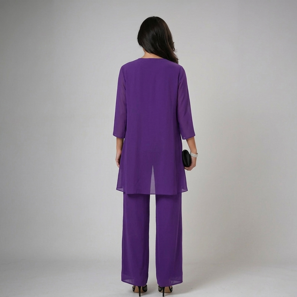 Back view of model in purple set with lace cuffs, holding a clutch in a studio backdrop.