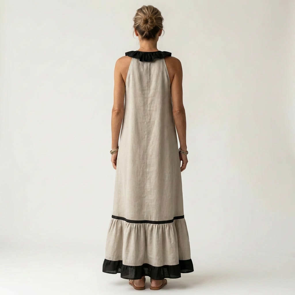 Back view of woman in beige sleeveless maxi dress with ruffle-neck and contrast trim in studio.