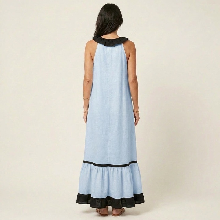 Back view of woman in light blue sleeveless maxi dress with ruffle-neck and contrast trim in studio.