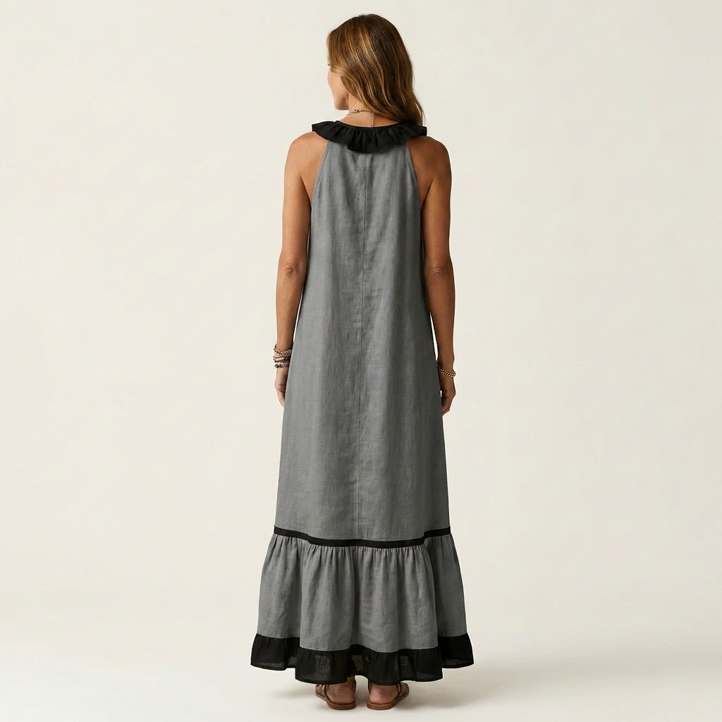Back view of woman in gray sleeveless maxi dress with ruffle-neck and contrast trim in studio.
