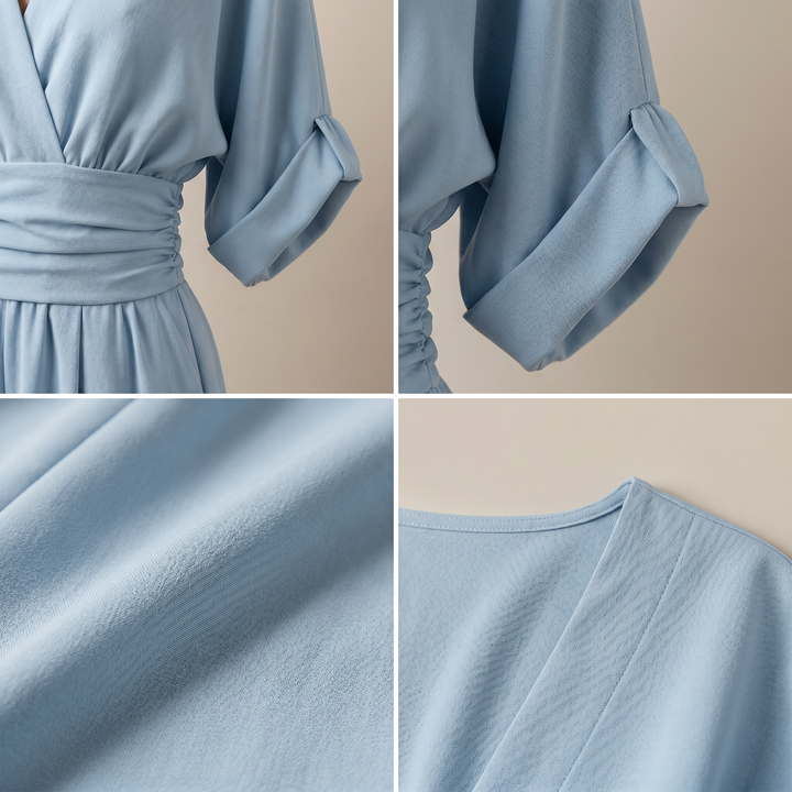 Close-up details of light blue jumpsuit showing V-neck, sleeve, fabric texture, and waistband in a studio setting.
