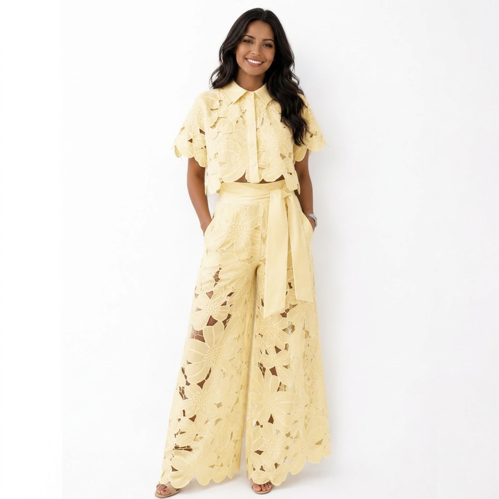 Woman in yellow floral lace set with wide-leg pants against a white studio background.