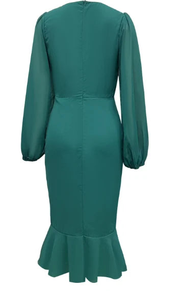 Back view of a green maxi dress with long sleeves and a ruffled hem, isolated on a white background.