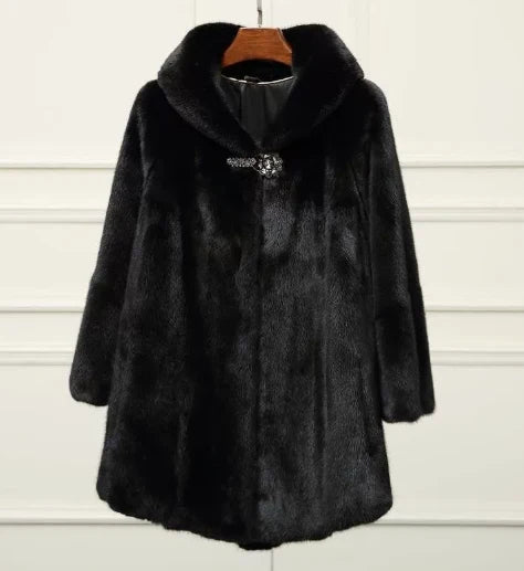 Luxurious black faux fur coat with a textured surface, featuring a large collar and embellished clasp, displayed on a hanger against a white paneled background.