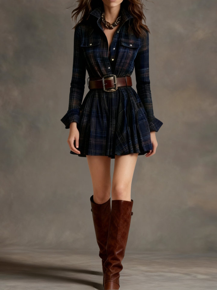 Dark plaid mini dress with a structured belt and knee-high boots styled in a studio setting.