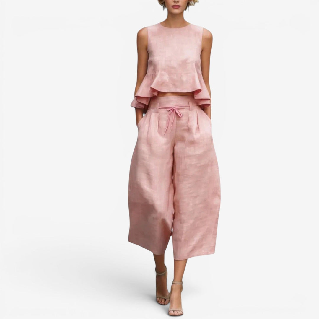 Pink two-piece set with sleeveless top and wide-leg pants in a studio setting.