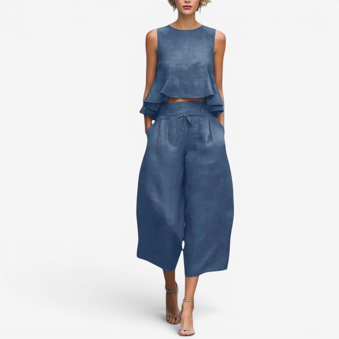 Blue two-piece set featuring a sleeveless top and wide-leg pants in a studio setting.