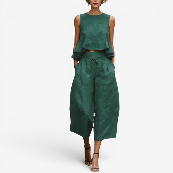 Green two-piece set with sleeveless top and wide-leg pants in a studio setting.