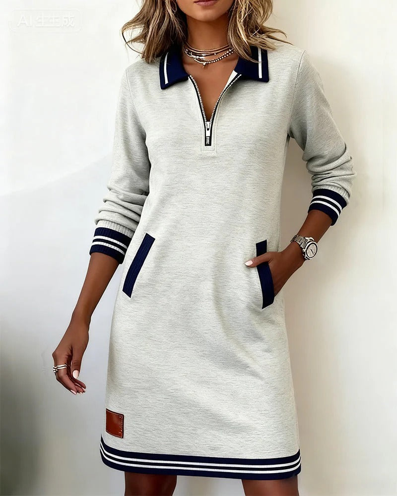 Heather gray dress with a zip front, navy accents, and side pockets, featured in a bright setting.