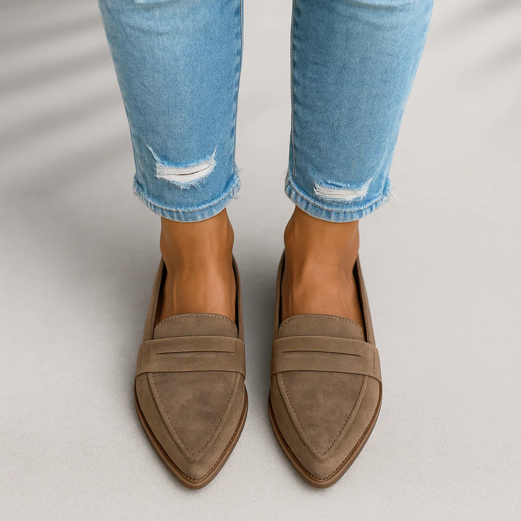 Person wearing taupe orthopedic moccasins and ripped light blue jeans on light gray background.