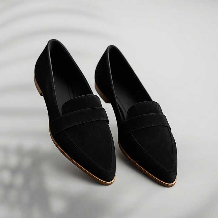 Pair of black orthopedic moccasins displayed on a light gray background indoors.