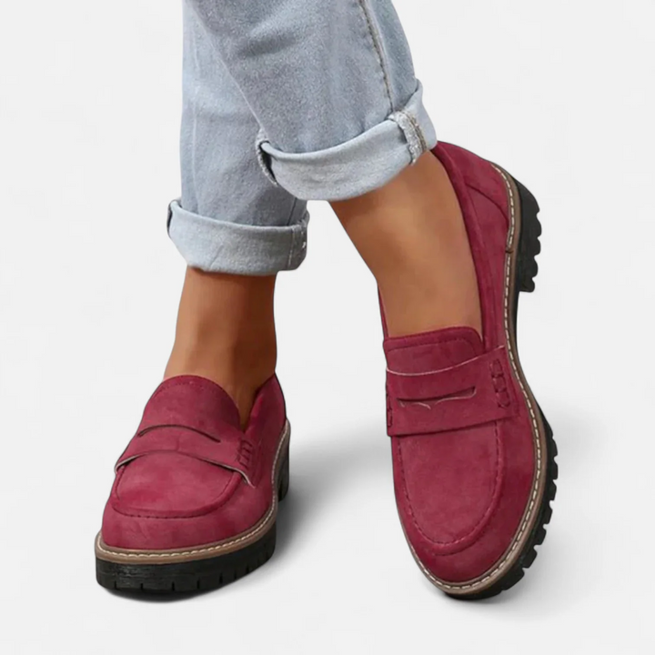 Red orthopedic moccasins paired with rolled-up jeans, displayed on a white background.