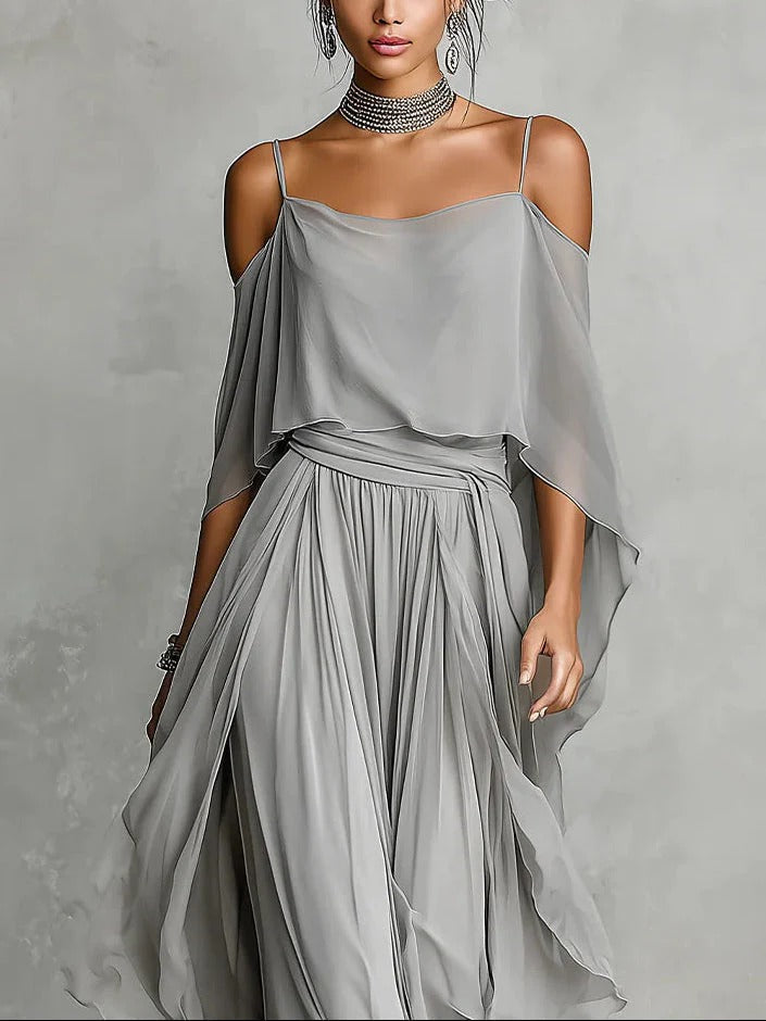 Close-up of gray flowy off-shoulder top and skirt set modeled in a studio setting.