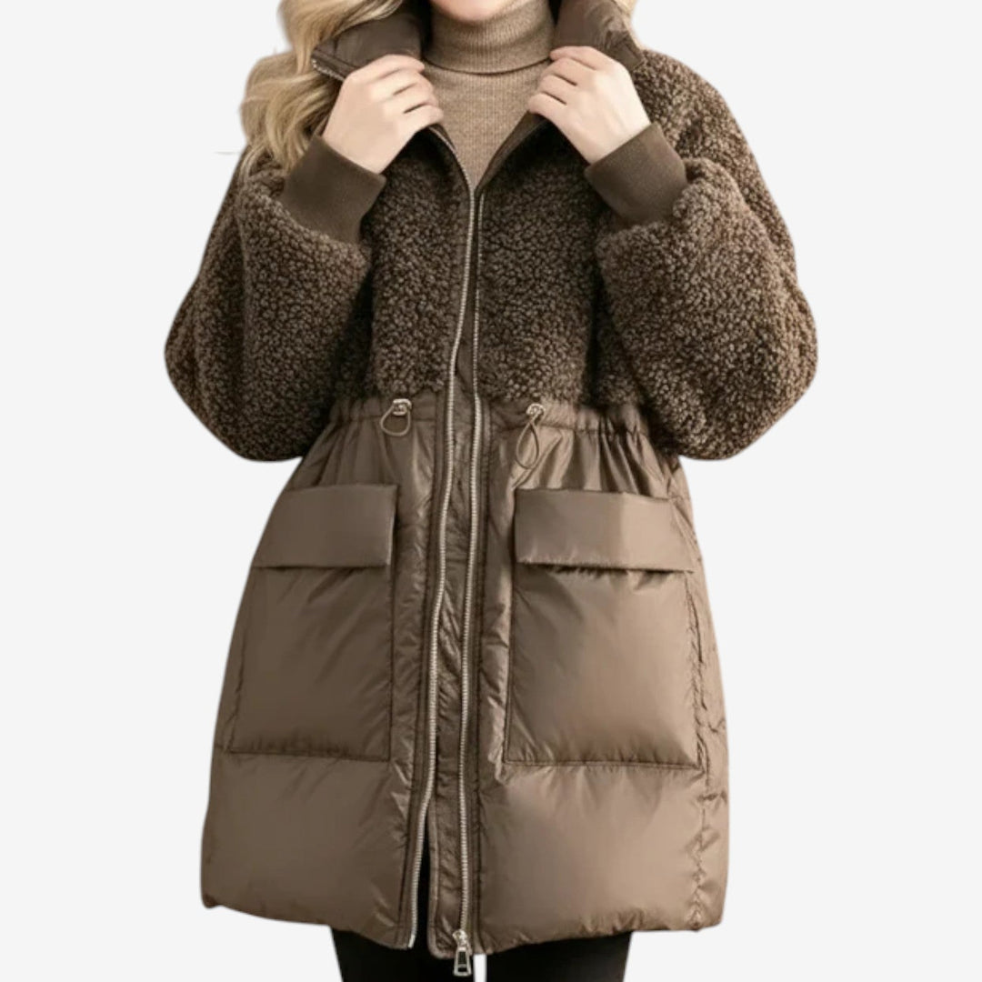 Brown winter coat with textured upper and smooth lower, worn by model in a neutral setting.