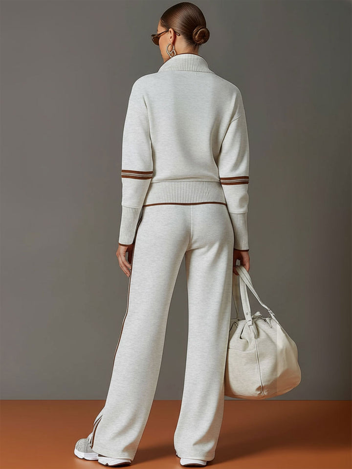Back view of matching lounge set in light gray with contrast stripes, paired with white sneakers and a bag in a studio setting.