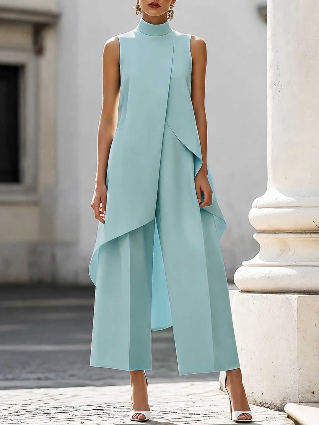 Light blue sleeveless jumpsuit with layered design in urban backdrop.