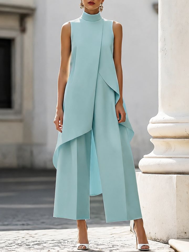 Light blue sleeveless jumpsuit with layered design in urban backdrop.