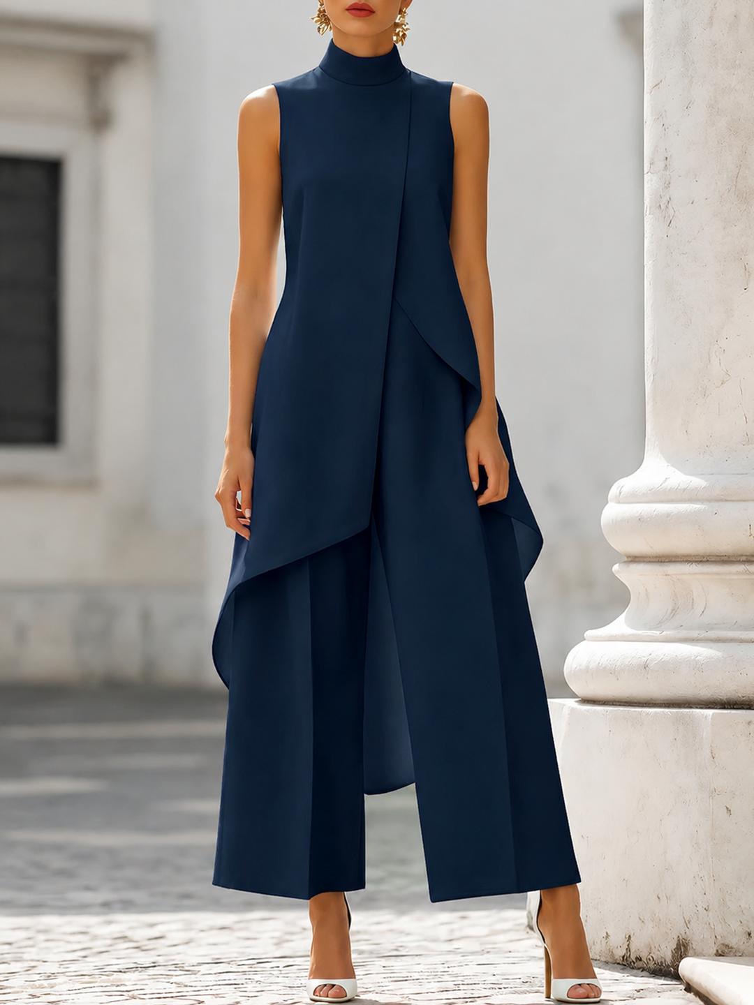 Navy sleeveless jumpsuit with layered design in refined urban setting.