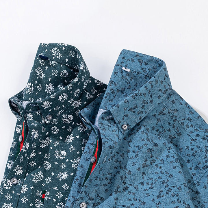 Two floral shirts in teal and blue with contrasting patterns, displayed side by side on a white surface.