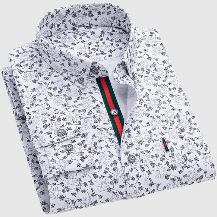 White floral shirt with black patterns, button-up collar, and contrasting interior stripe, studio backdrop.