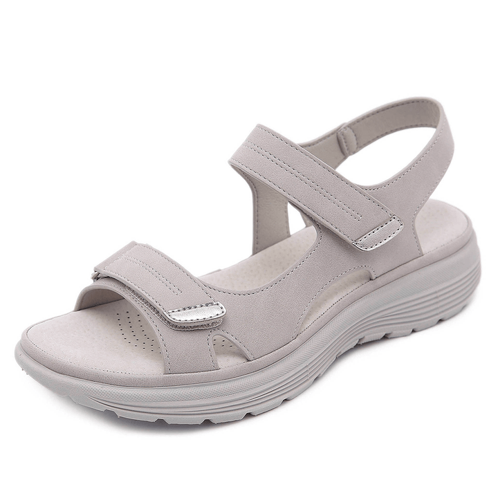 Light gray orthopedic sandal with adjustable straps and cushioned sole, studio background.