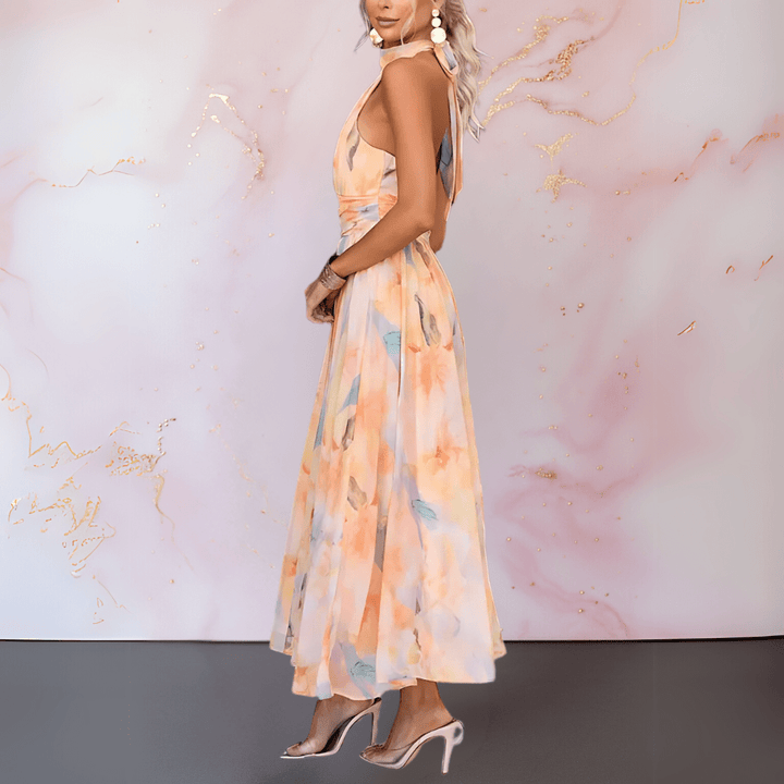 Side view of an elegant printed dress with halter design, paired with earrings in a pastel studio setting.