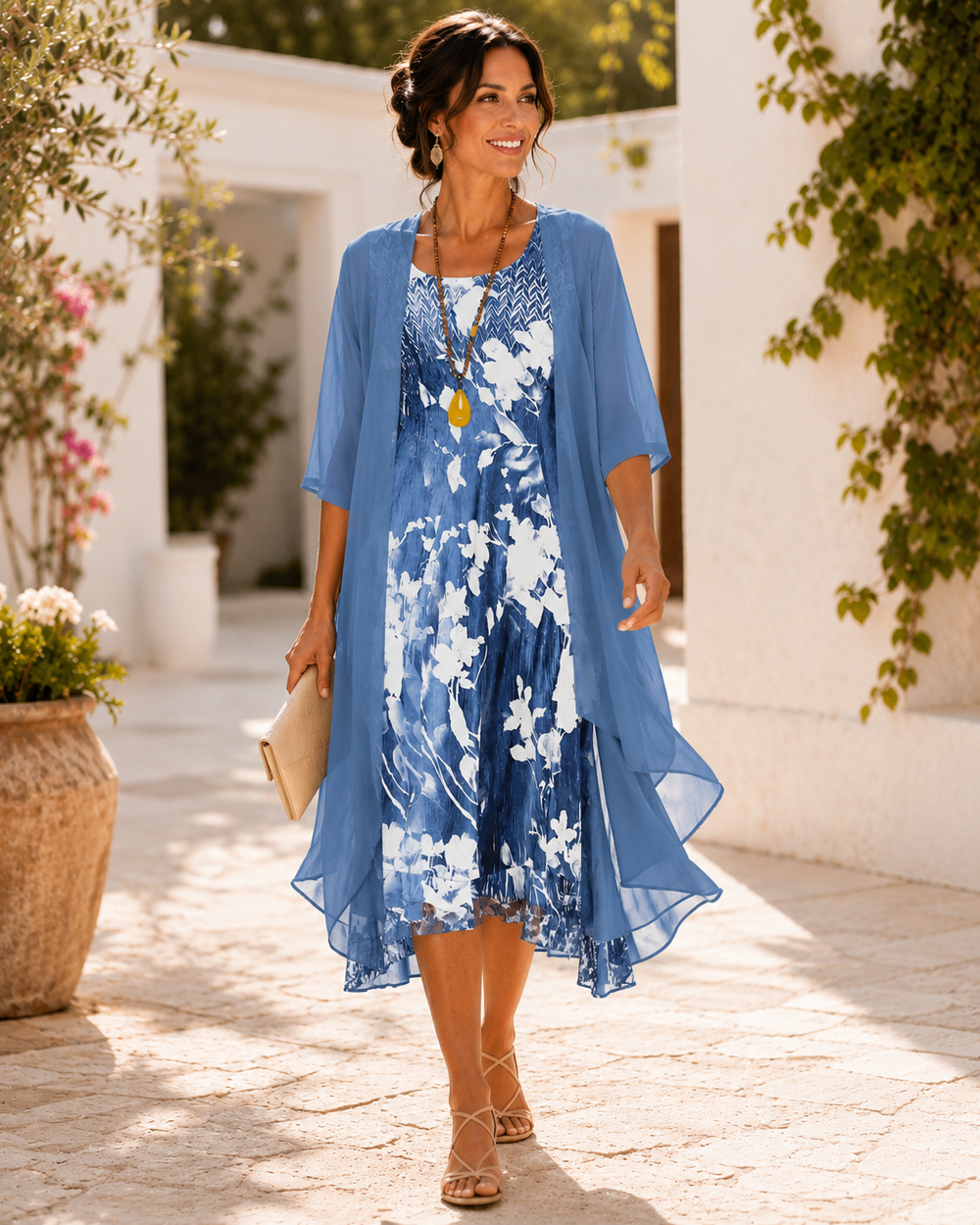 Woman walking in blue, floral two-layer dress, an outdoor setting with terracotta pots and greenery.