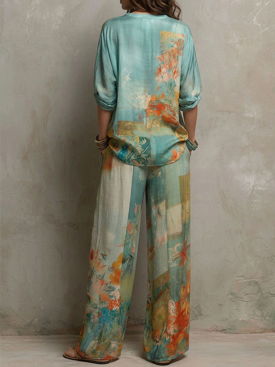 Back view of a woman in a teal and orange floral blouse and pants set, against a textured wall background.