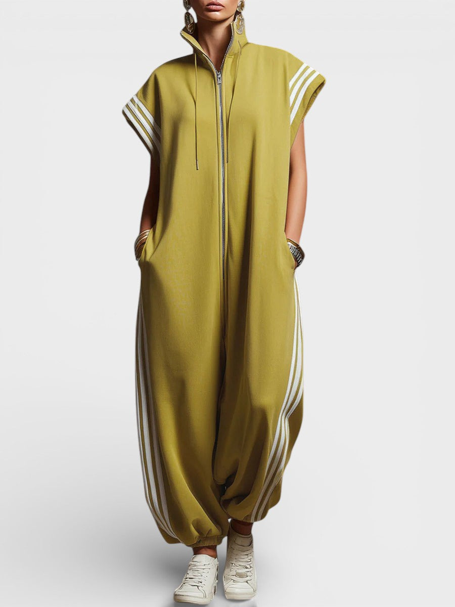 Model wearing olive green zip neck jumpsuit with white side stripes and cap sleeves, studio background.