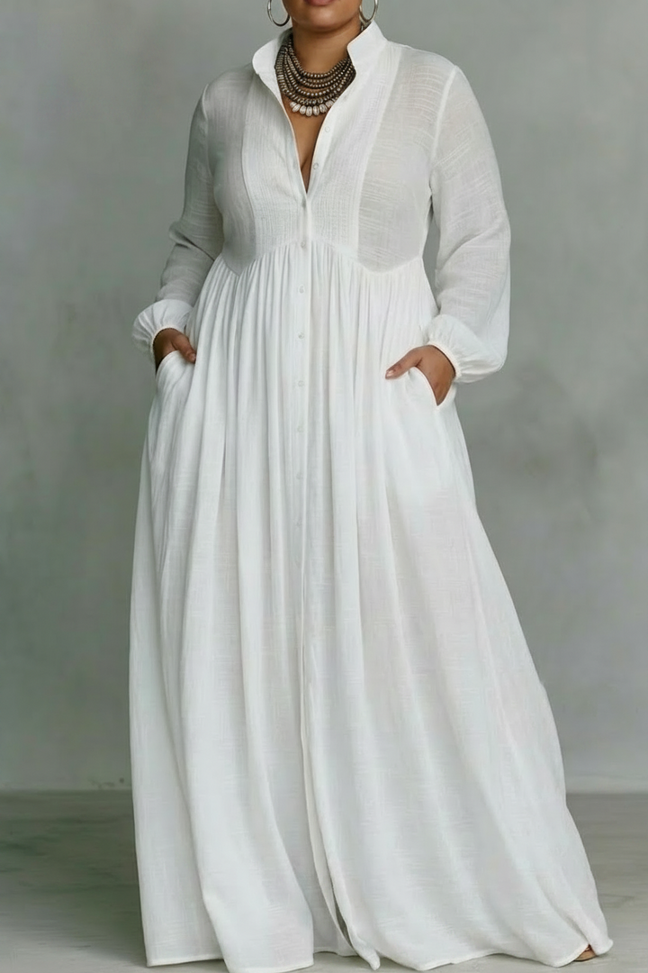 White flowing button-front maxi dress with long sleeves in a studio setting.