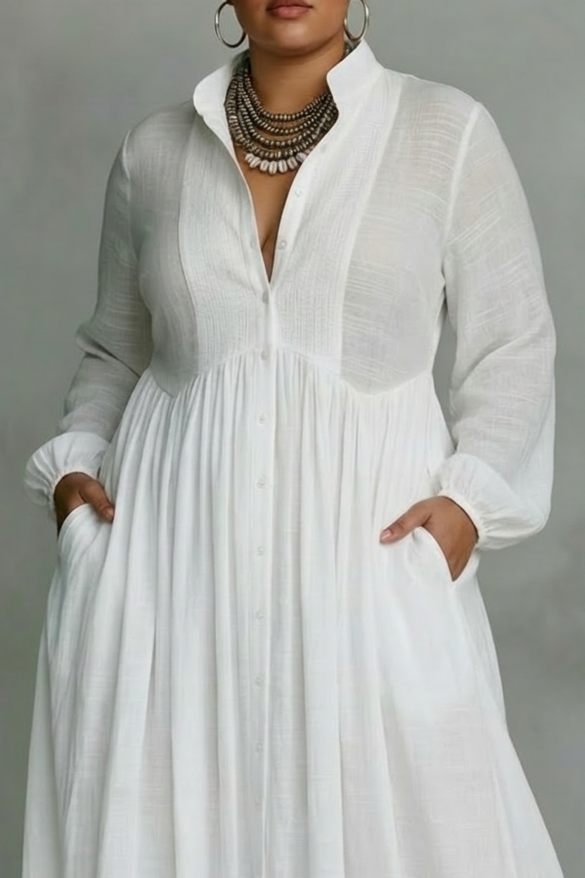 Close-up of white flowing button-front maxi dress top with long sleeves in a studio setting.
