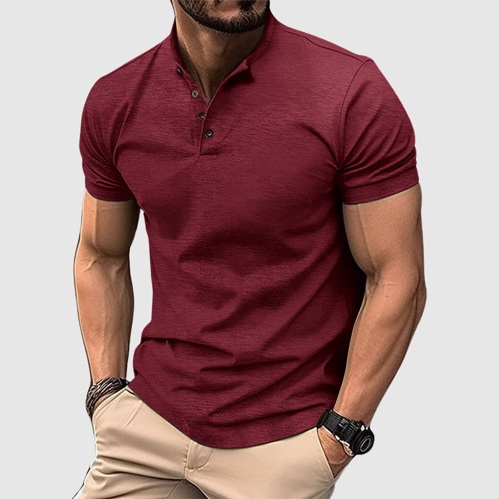 Man wearing a maroon breathable polo shirt with buttoned collar, paired with beige pants, in a studio setting.