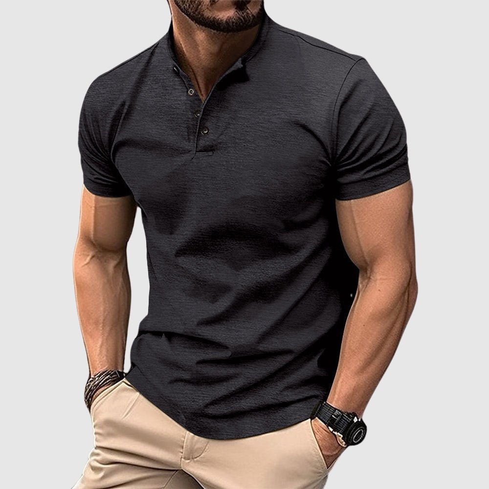 Man wearing a black breathable polo shirt with buttoned collar, paired with beige pants, in a studio setting.