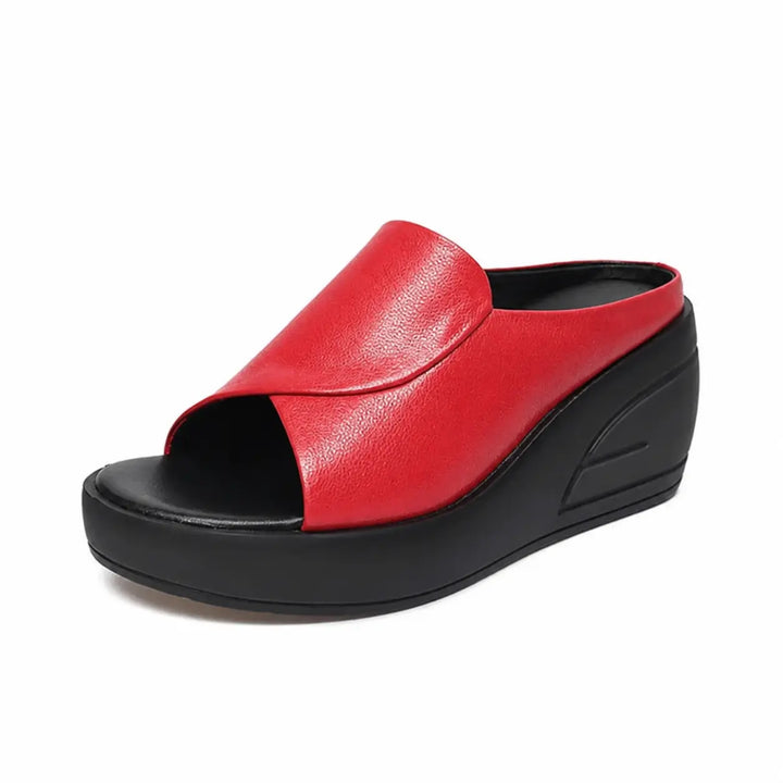 Red orthopedic slip-on wedge sandal with a clean minimalist strap, set in a studio background.