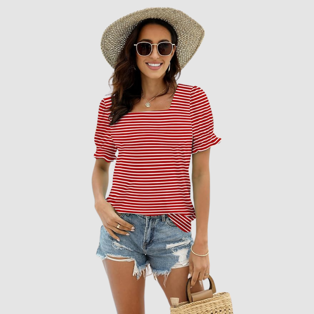 Woman in red-striped square neck top, denim shorts, straw hat. Relaxed style in studio setting.