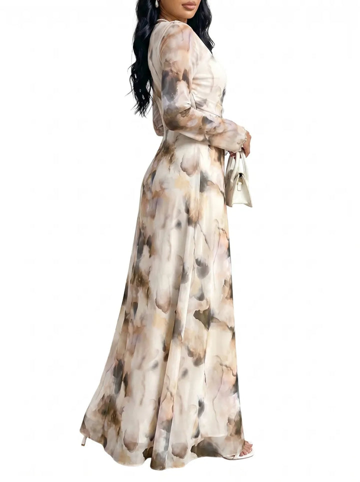 Side view of an elegant long dress with an abstract watercolor design, long sleeves, paired with a white handbag, studio environment.
